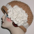 tan women's hat with extra large fascinator flower